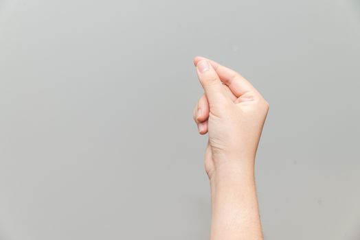 Human hand holding imaginary card on light gray background