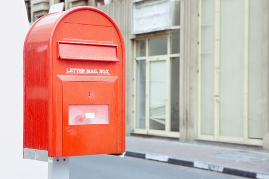 Red mail box outdoors with English text. Horizontal photo