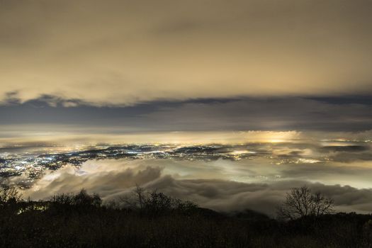 Fog in the night over the lake and the city of Varese, Lombardy - Italy