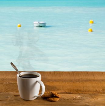 Morning cup of coffee on a wooden picnic table on St Martin in Caribbean in idyllic dreamlike location with a power boat moored just off the deck