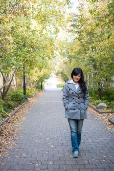 Portrait of beautiful lonely girl walking down a road bonded by trees