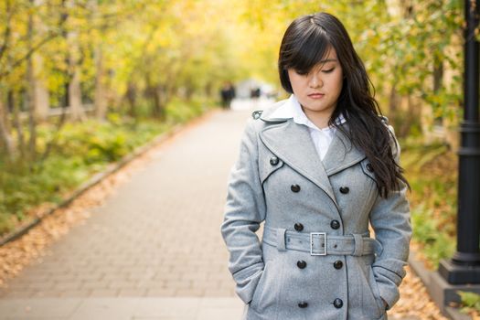 Close up portrait of attractive young girl alone on a road looking depressed