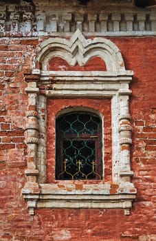 Peeling brick wall of an ancient monastery and stucco window