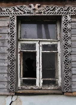 Window with decorative platband on old abandonned wooden house