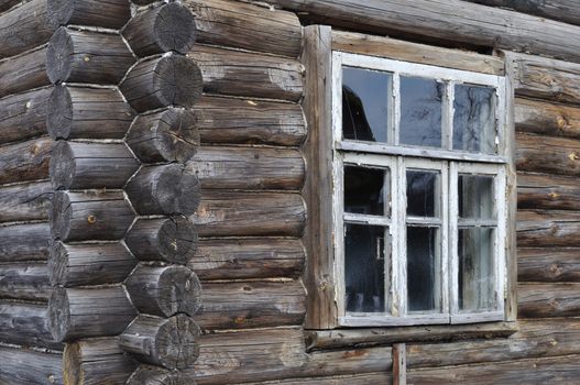 Fragment of old wooden house wall with window