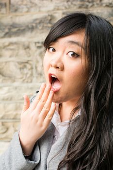 Portrait of attractive young woman looking surprised and screaming out loud and looking cute