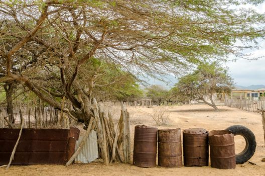 Rusted barrels making a fence in a rural village in La Guajira, Colombia