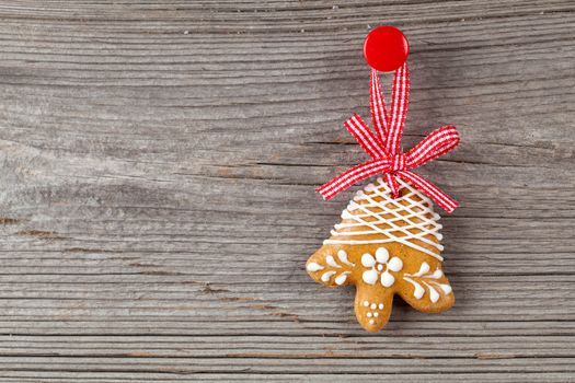 Gingerbread cookie hanging on wooden background. Christmas decoration.