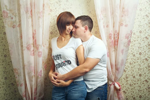 Happy newlyweds hugging T-shirts, shot in the studio