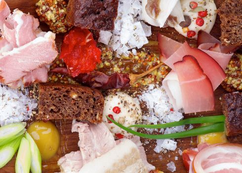 Background of Various Uncooked, Smoked and Boiled Ham with Mustard, Salt, Pepper, Brown Bread, Spring Onion and Spices closeup on Wooden Plate