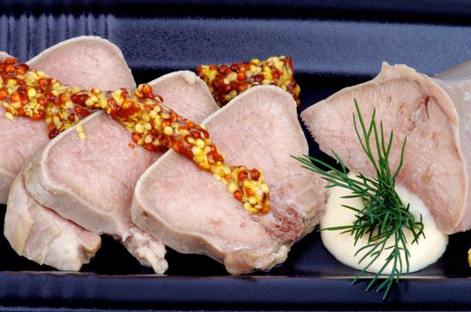 Sliced Boiled Beef Tongue with Whole Grain Mustard, Horseradish and Dill closeup on Black Plate
