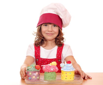 beautiful little girl cook with cupcakes