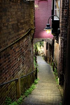 narrow walkway steps leading downhill with an Old-fashioned light, dust lighting high contrast and saturation