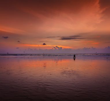 Couple walking on beach on romantic sunset. Baga beach. Goa, India