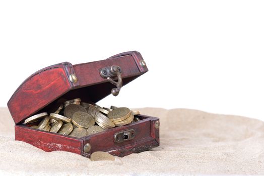 small treasure box open with gold coins inside part buried in the sand isolated on white background