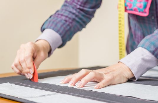 Woman dressmaker design tailor pattern for a suit on the table