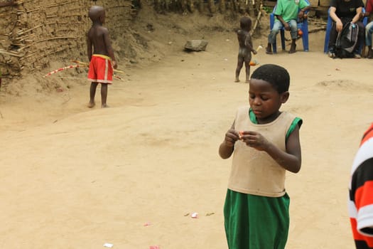 Uganda - March 6: a young African girl opens the candy that was given to tourists on 6 March 2012 in Uganda.