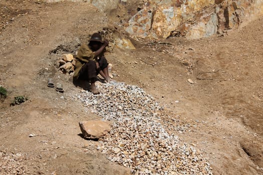 Uganda - 6 March: African man crushes stone for road construction 6 March 2012 in Uganda.