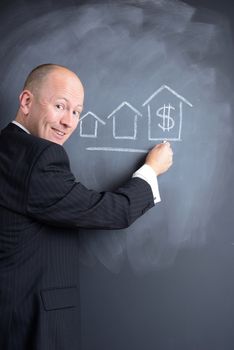 pointing to a growth chart of construction or housing on a blackboard