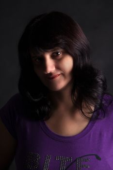 portrait of a beautiful young woman in a blue blouse on a dark background