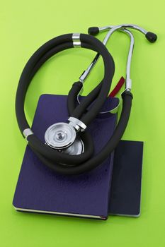 Stethoscope placed on small notebooks against fresh, green background suggestive of new policy, ideas, and concepts on medicine and health care
