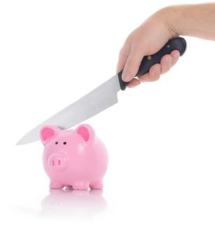 breaking into piggy bank with a knife to access funds isolated on a white background