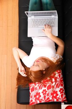 A young woman surfing on the Internet with a Laptop.  