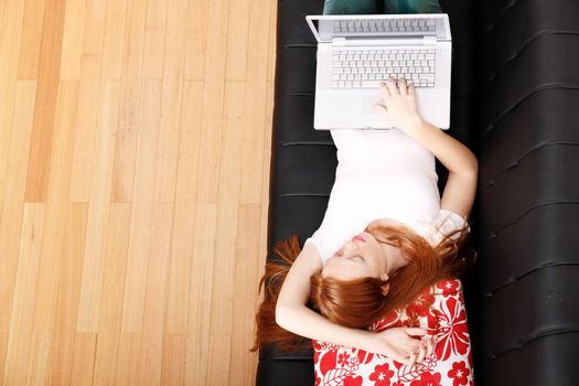 A young woman surfing on the Internet with a Laptop.  