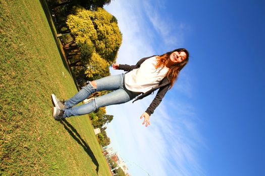 A young woman jumping in the Park.			