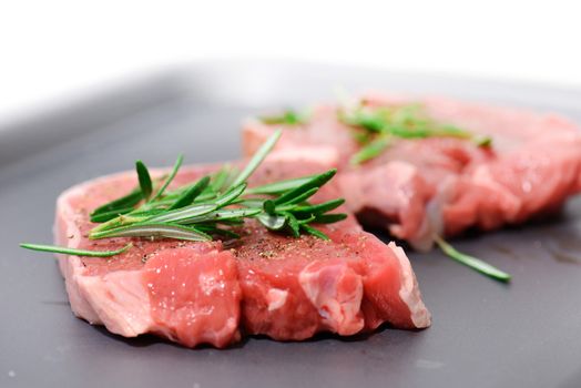 two tasty lamb steaks with rosemary dressing ready to cook in soft focus