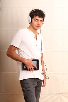 A young, latin man with a Tablet PC and headphones
