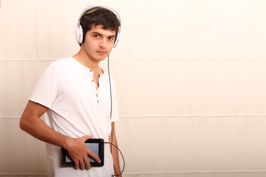 A young, latin man with a Tablet PC and headphones
