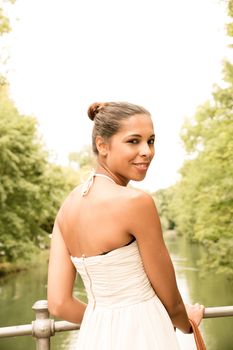 A young girl standing on a bridge.