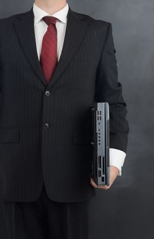 businessman holding a laptop ready for business