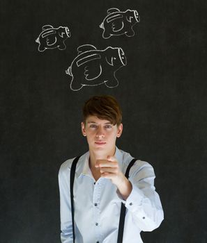 Businessman pointing with flying money piggy banks in chalk on blackboard background