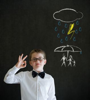 Thinking boy dressed up as business man thinking about protecting family from natural disaster on blackboard background