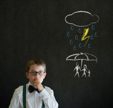 Thinking boy dressed up as business man thinking about protecting family from natural disaster on blackboard background