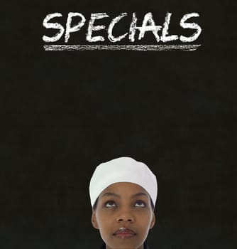 African American woman chef with chalk specials sign on blackboard background