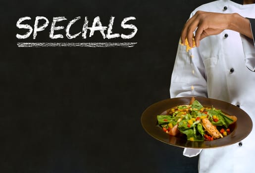 African American woman chef with chalk specials sign on blackboard background