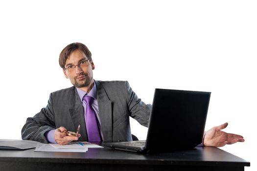 businessman in glasses behind a desk in an office with a clock in his hands