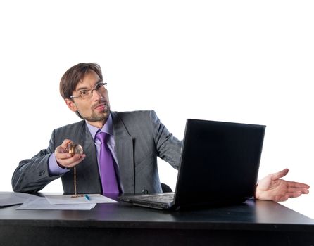 businessman in glasses behind a desk in an office with a clock in his hands