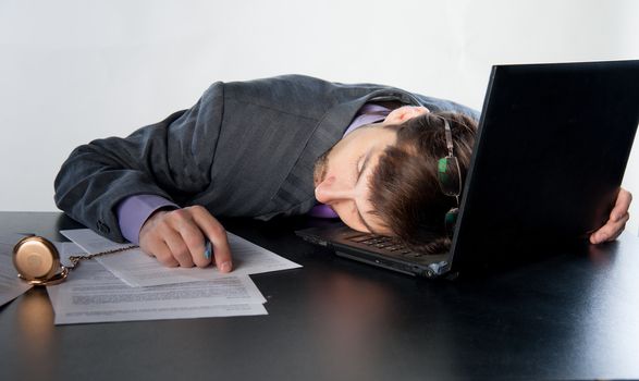 man asleep on a laptop in the workplace