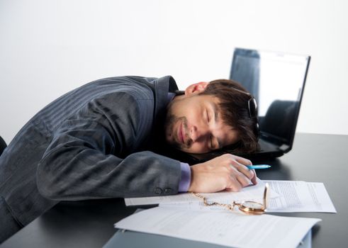 man asleep on a laptop in the workplace