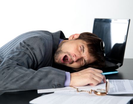 man yawns on a laptop at work