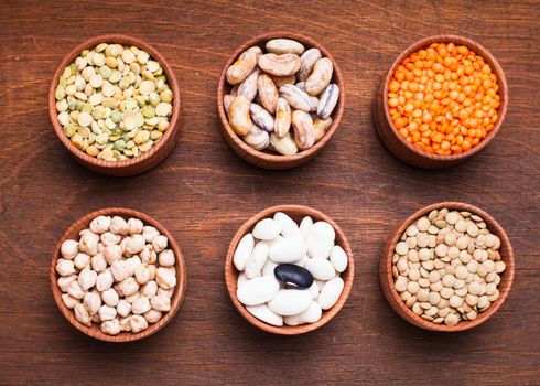 Different types of beans in wooden bowls