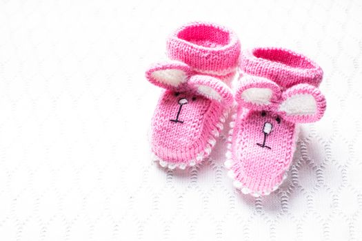 Knitted pink baby booties and blanket for little girl