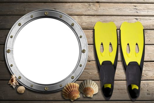 Metal empty porthole with seashells and yellow and black flippers on wooden floor with sand