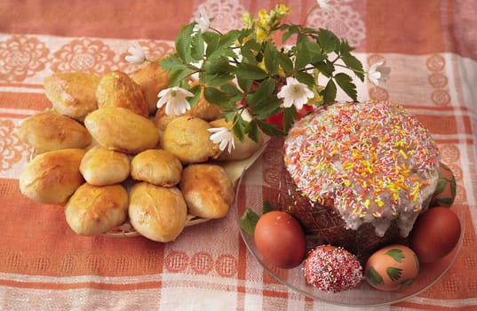 Easter table with eggs cakes and flowers
