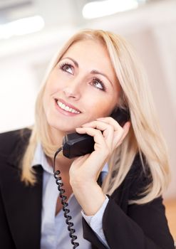 Beautiful businesswoman talking on the phone in the office