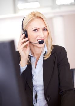 Beautiful call center operator talking over the phone in the office